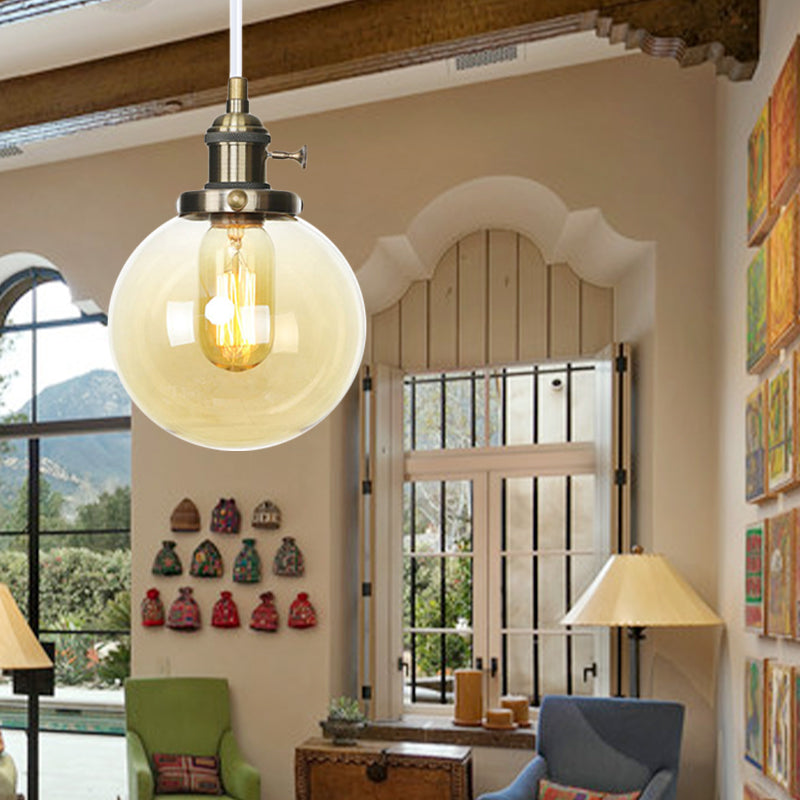 Orbit Hanging Lighting Farmhouse Amber/Clear Glass 1 Bulb Pendant Light Fixture with Adjustable Cord in Black/Bronze/Brass Finish Clearhalo 'Art Deco Pendants' 'Black' 'Cast Iron' 'Ceiling Lights' 'Ceramic' 'Crystal' 'Industrial Pendants' 'Industrial' 'Metal' 'Middle Century Pendants' 'Pendant Lights' 'Pendants' 'Rustic Pendants' 'Tiffany' Lighting' 273904