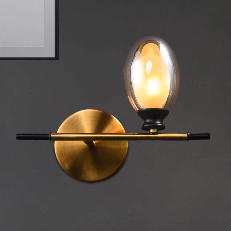 Clear/Amber Glass Egg Shape Wall Light Fixture Minimalist 1 Light Brass Sconce with Horizontal Arm Amber Clearhalo 'Cast Iron' 'Glass' 'Industrial' 'Modern wall lights' 'Modern' 'Tiffany' 'Traditional wall lights' 'Wall Lamps & Sconces' 'Wall Lights' Lighting' 275247