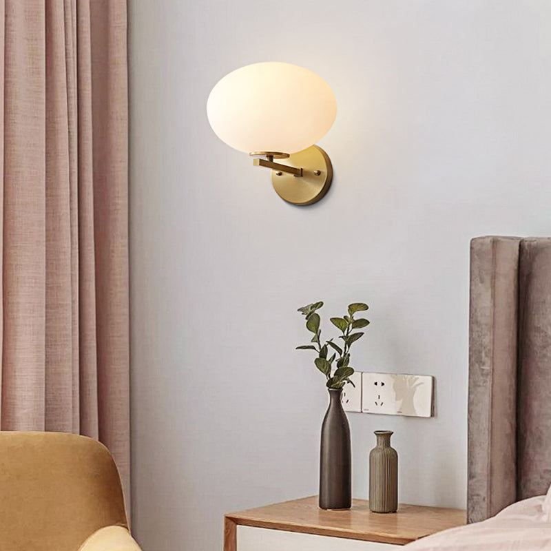 Milk Glass Oval Wall Mount Lamp Modern 1 Light Bedside Wall Sconce Light in Brass Brass Clearhalo 'Cast Iron' 'Glass' 'Industrial' 'Modern wall lights' 'Modern' 'Tiffany' 'Traditional wall lights' 'Vanity Lights' 'Wall Lights' Lighting' 370184